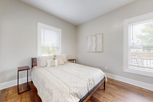 a white bedroom with a bed and two windows at Norris Villa 2 in La Follette