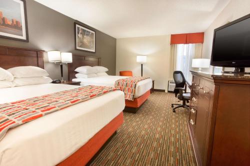 a hotel room with two beds and a flat screen tv at Drury Inn & Suites St. Louis Airport in Edmundson