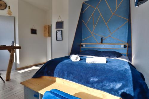 a bedroom with a blue bed with two towels at Superbe studio cosy et atypique 3 étoiles in Montbéliard