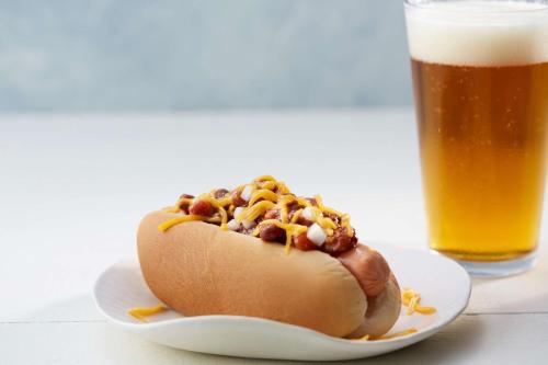 a hot dog on a plate next to a glass of beer at Drury Inn & Suites Huntsville Space & Rocket Center in Huntsville
