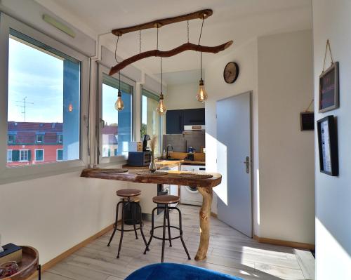 een keuken met een tafel en stoelen in een kamer bij Superbe studio cosy et atypique 3 étoiles in Montbéliard