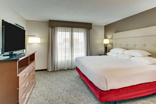 a hotel room with a large bed and a flat screen tv at Drury Plaza Hotel St. Paul Downtown in Saint Paul