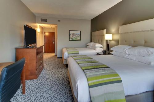 a hotel room with two beds and a flat screen tv at Drury Inn & Suites Columbus Polaris in Columbus