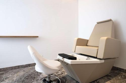 a barber chair and a white chair in a salon at Radisson Blu Resort Al Hoceima in Al Hoceïma