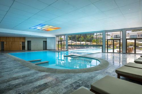 a large swimming pool in a building with windows at Radisson Blu Resort Al Hoceima in Al Hoceïma