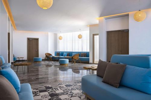 a living room with blue couches and tables at Radisson Blu Resort Al Hoceima in Al Hoceïma