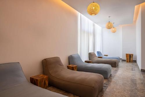a living room with three couches and two chairs at Radisson Blu Resort Al Hoceima in Al Hoceïma