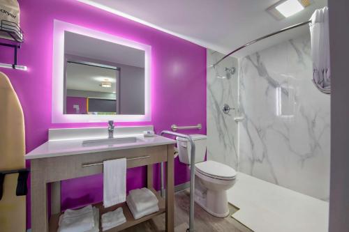 a purple bathroom with a sink and a toilet at Motel 6 Tuscaloosa AL University in Tuscaloosa