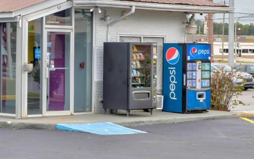 a pepsi and a soda machine in front of a store at Motel 6 Tuscaloosa AL University in Tuscaloosa