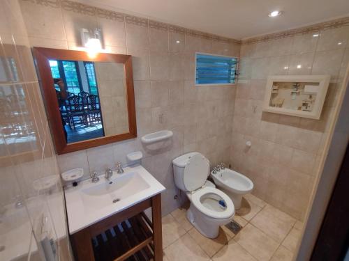 a bathroom with a toilet and a sink at La Pocilga in Paso de la Patria
