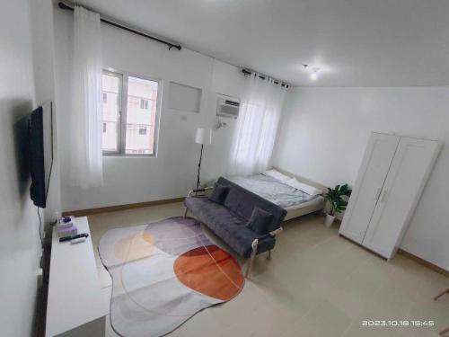 a living room with a couch and a tv at Ace That Condo Staycation Cheer Residences beside SM Marilao in Marilao