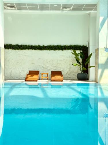 two brown chairs sitting next to a swimming pool at Royal Kate Apartments Spa included 30th floor in Skopje