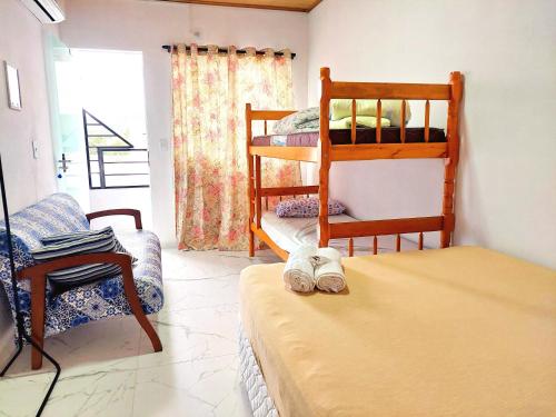 a room with two bunk beds and a bed with a hat at Aconchego Sol e Mar in Navegantes