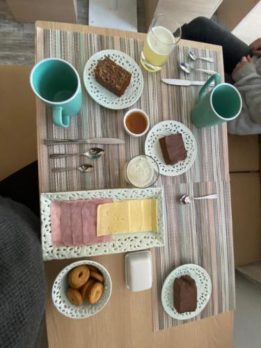 a table with different types of food on it at Indomito Sur Hostel in Punta Arenas