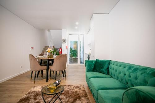 a living room with a green couch and a table at City Glow House in Ponta Delgada