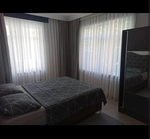 1 dormitorio con 1 cama y 2 ventanas grandes en Stylish Apartment, en Estambul