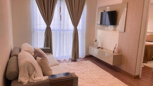een woonkamer met een bank en een tv bij Elegante Apartamento, com ótima localização, na principal avenida de entrada em Bagé in Bagé