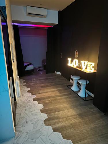 Una habitación con un cartel que dice amor en la pared en Love room borabora 3 en Trévoux