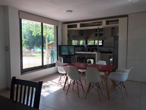 een keuken en eetkamer met een tafel en stoelen bij Boutique Casa en Comuna san Roque in San Roque