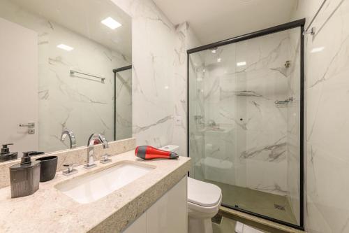 uma casa de banho com um chuveiro, um lavatório e um WC. em LIV Apartamento 1705 em Porto Alegre