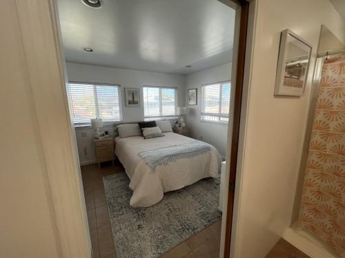 um quarto com uma cama num quarto com janelas em Kailani Loft, Kailua Coconut Grove 1-bedroom em Kailua