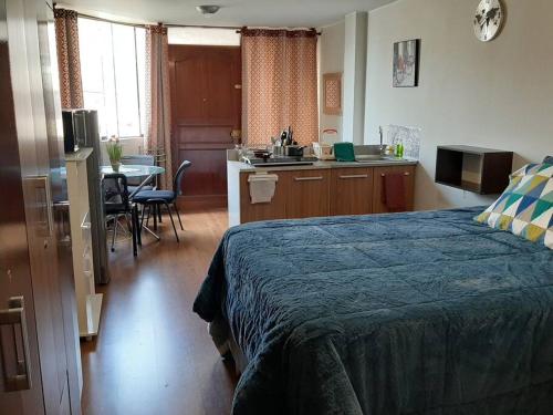 1 dormitorio con 1 cama y cocina con mesa en Hermoso MiniDepa de Estreno en La Molina en Lima