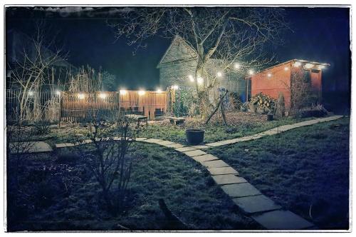 een tuin 's nachts met lichten op een hek bij Cinderella Guitars 