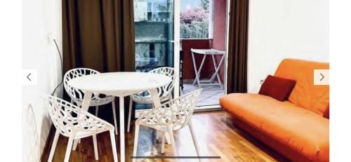 uma sala de estar com uma mesa e cadeiras e um sofá em Monte Star apartments em Budva