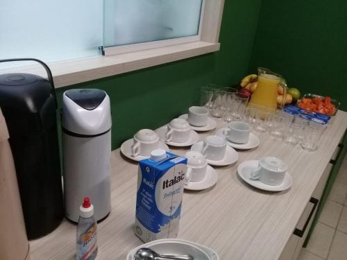 una mesa con tazas, platillos y vasos. en Hotel Parati, en Morro da Fumaça