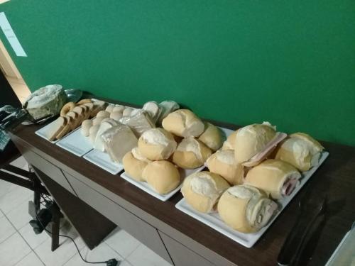 een tafel met sandwiches en gebak bij Hotel Parati in Morro da Fumaça