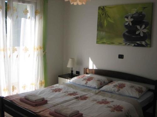 een slaapkamer met een bed en een raam met een schilderij bij Apartment in Rogoznica - Sibenik Riviera 36449 in Rogoznica