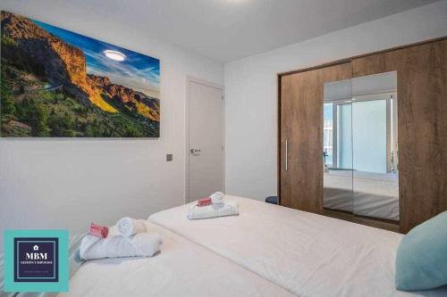 a bedroom with a large bed with a painting on the wall at Playa Verde Las Canteras in Las Palmas de Gran Canaria