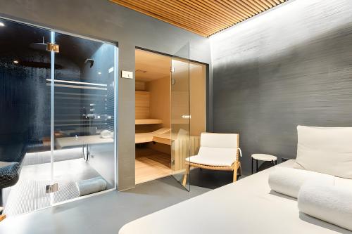 sypialnia z białym łóżkiem i biurkiem w obiekcie Portopiccolo Designer Penthouse w mieście Sistiana