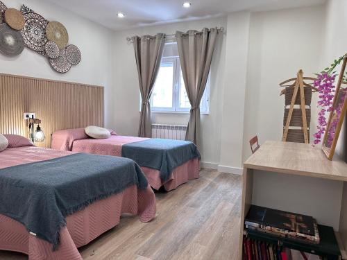 ein Schlafzimmer mit zwei Betten und einem Fenster in der Unterkunft La Casita de Tita in Salamanca