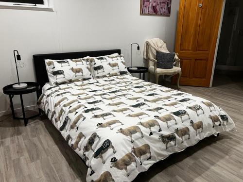 um quarto com uma cama grande com cobertor de ovelhas em Short Stay- ENTIRE GUESTHOUSE! em Halcombe