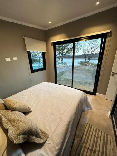 een slaapkamer met een groot bed en een groot raam bij Cabaña Vinson Cabra Corral in Coronel Moldes