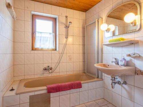 uma casa de banho com uma banheira e um lavatório em Appartement Brixnerwirt I em Brixen im Thale