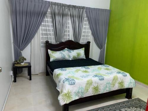 a bedroom with a bed and a window at ALEENA STAYCATION @ APARTMENT TOK PELAM PANTAI BATU BURUK in Kuala Terengganu
