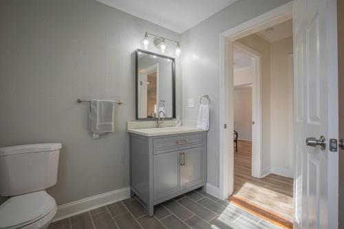 a bathroom with a sink and a toilet and a mirror at Cara's Cottage 2 miles from Sanford Stadium in Athens