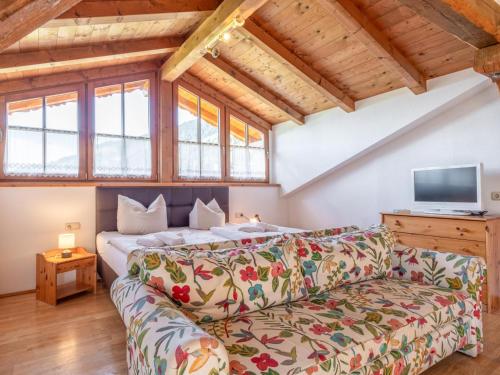 a living room with a couch and a tv at Appartement Brixnerwirt IV in Brixen im Thale