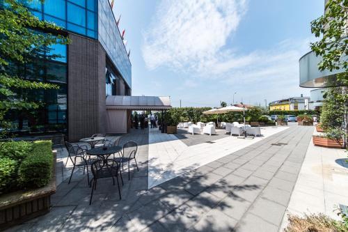 a patio with tables and chairs in front of a building at Airport Hotel Bergamo in Bagnatica