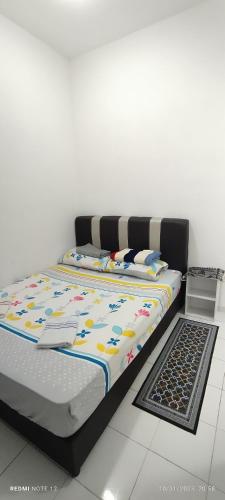 a bed in a room next to a floor at Nizmar Inn 2 Guesthouse & Homestay in Gambang