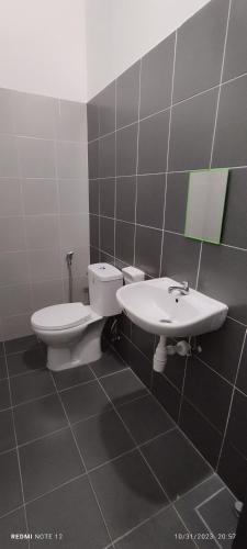 a bathroom with a toilet and a sink at Nizmar Inn 2 Guesthouse & Homestay in Gambang