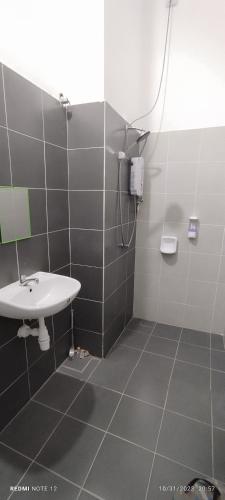 a bathroom with a sink and a shower at Nizmar Inn 2 Guesthouse & Homestay in Gambang