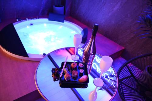 Suite Cavour Exclusive House Private Luxury SPA في برينديسي: طاولة مع وعاء من الطعام وزجاجة من النبيذ