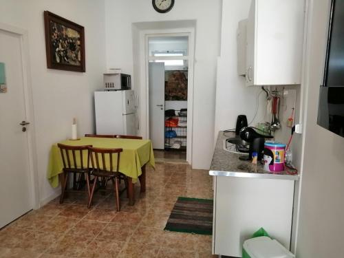 a kitchen with a table and a yellow table and chairs at Ajuda Space in Lisbon
