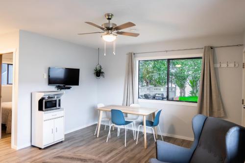 a living room with a table and chairs and a window at Poplars Motel on the lake in Osoyoos