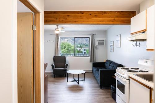 a kitchen and living room with a couch and a table at Poplars Motel on the lake in Osoyoos