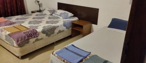 1 dormitorio con 2 camas y mesa en Hotel Villa Elisa en Villa Elisa