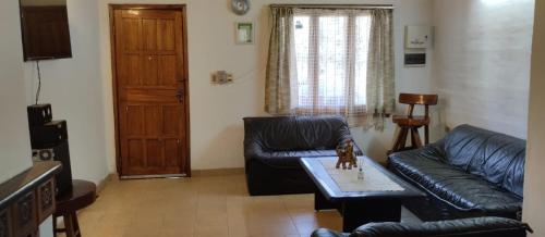 sala de estar con sofá de cuero y mesa en Hotel Villa Elisa en Villa Elisa